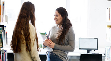 Image for Students talking in a library